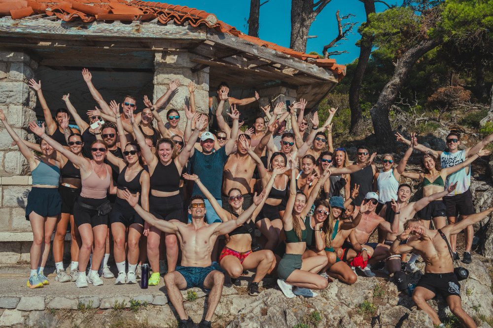 A SurfYogaBeer crew in Croatia with their arms in the air